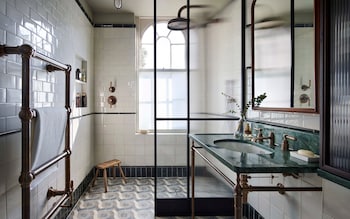 Divide and rule: brass fittings and a green marble sink add classic style to this shower room